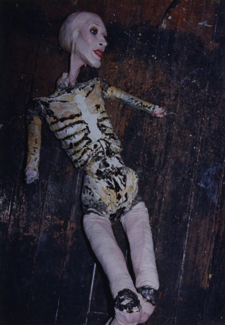 Sissy doll mid-operation. Her arms have been removed at the elbows, and her ribcage is visible.