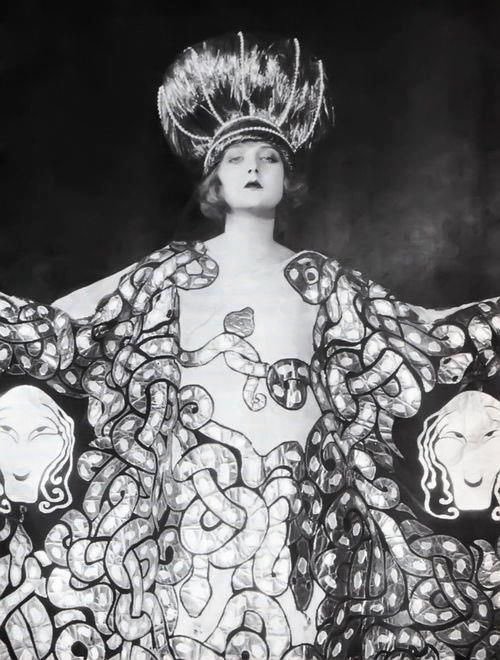 Mary in a costume designed by Erté for the 1923 Ziegfeld Follies. The costume is printed with gilded serpents, and she wears a feathered headdress.